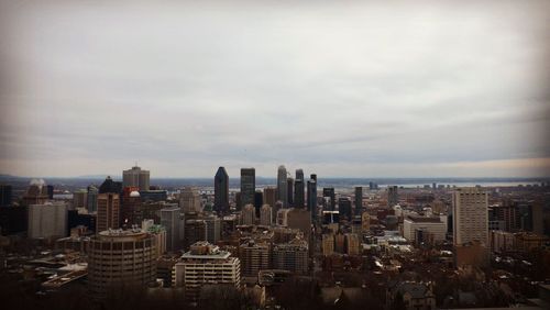 Aerial view of buildings in city against sky