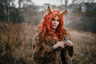 Portrait of beautiful young woman standing in winter