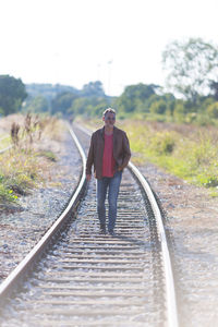 Single man walking on railroad tracks