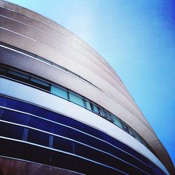 Low angle view of modern building against blue sky