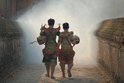 Rear view of people walking in water