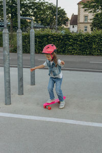 Full length of boy with umbrella walking on road