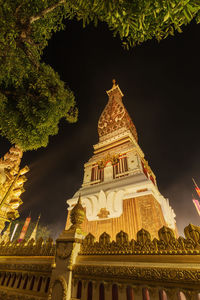 Low angle view of illuminated building against sky at night