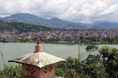 Scenic view of townscape by mountains against sky