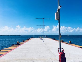 Street by sea against blue sky