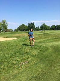 Full length of man on golf course on field against sky