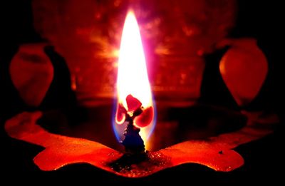 Close-up of lit candle in dark room