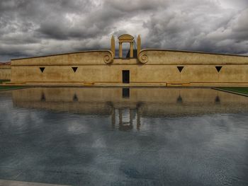 Built structure in water against cloudy sky