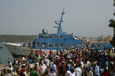 Crowd on sea against clear sky