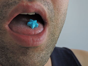 Close-up of man eating blue candies