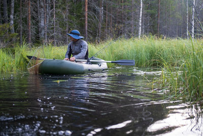 Man in lake against trees in forest