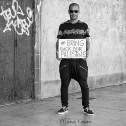 Full length portrait of man standing against wall