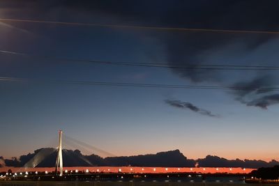 Bridge over river against sky at sunset