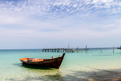 Sailboats moored on sea against sky