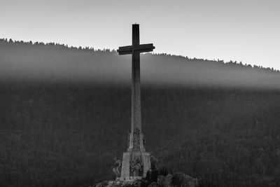 Cross on field against clear sky