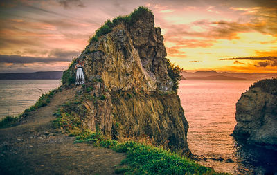 Scenic view of sea against dramatic sky during sunset