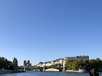 Bridge over river by notre dame against clear blue sky in paris