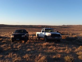 Truck on field against clear blue sky