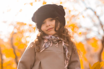 Close-up portrait of smiling girl standing during autumn