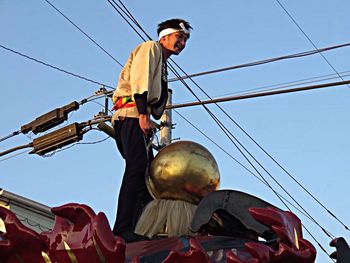 Low angle view of people against blue sky