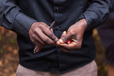 Close-up of man holding nut in forest