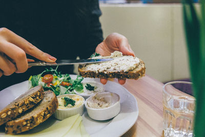 Midsection of woman applying dip on bread