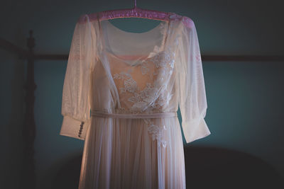 Rear view of woman standing against white curtain at home