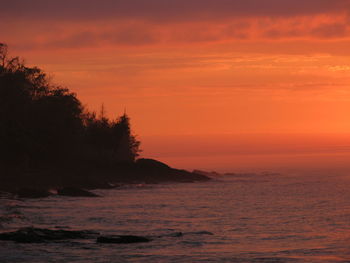 Scenic view of sea against romantic sky at sunset