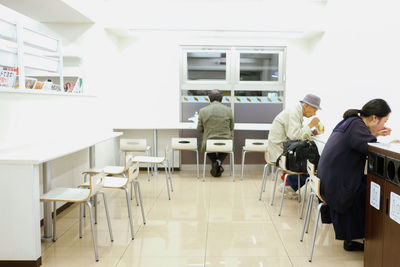 Rear view of people sitting on table