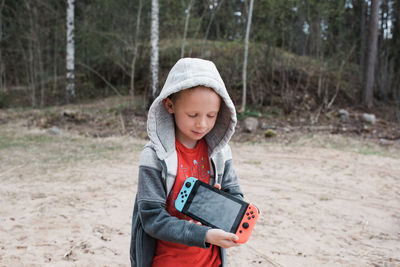 Young boy holding a nintendo games console sharing the screen