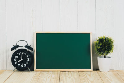 Clock on table against white wall