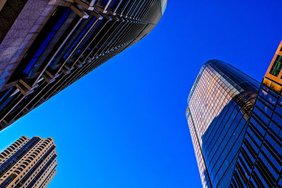 Low angle view of skyscrapers against clear blue sky