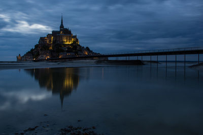 Buildings by pier at beach against sky