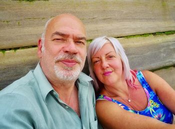 Portrait of smiling mature couple against wall