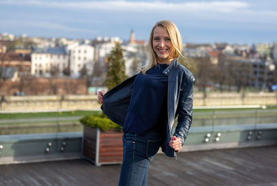 Portrait of young woman standing in city