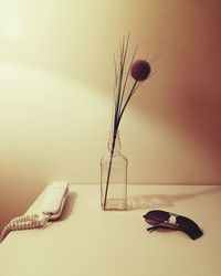 Close-up of vase on table against wall