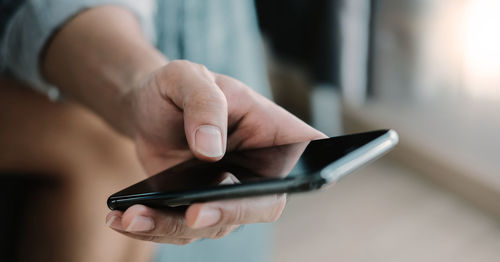 Midsection of man using mobile phone