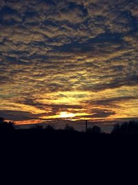 Silhouette of landscape against cloudy sky