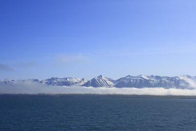 Scenic view of snowcapped mountains against blue sky