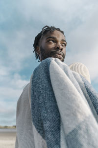 Low angle view of man looking away against sky