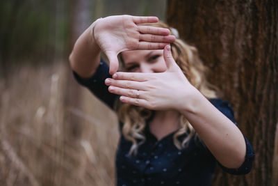 Midsection of woman standing by tree