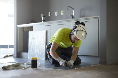 Worker installing floor in kitchen