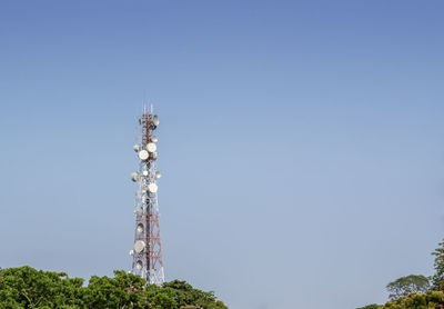 Low angle view of electricity pylon against clear blue sky