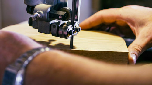 Close-up of hand operating machine in factory