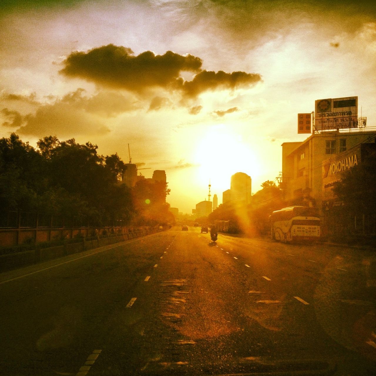 sunset, transportation, the way forward, sky, sun, street, car, road, building exterior, land vehicle, architecture, built structure, sunlight, mode of transport, diminishing perspective, vanishing point, cloud - sky, silhouette, city