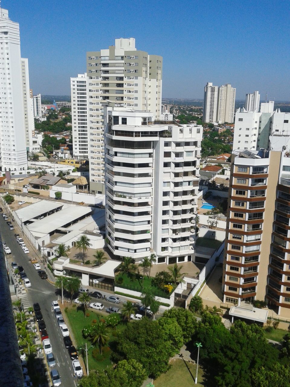 building exterior, architecture, built structure, city, cityscape, high angle view, residential district, residential building, residential structure, tree, skyscraper, crowded, clear sky, city life, blue, modern, building, office building, sunlight, sky