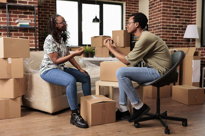 Couple talking while sitting by cardboard