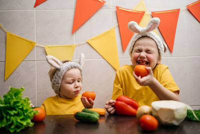 Children in rabbit ears eat herb dill vegetables easter. high quality photo