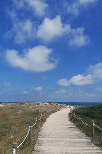 View of empty road on beach against sky