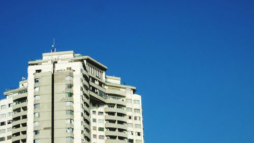 Low angle view of buildings against clear blue sky